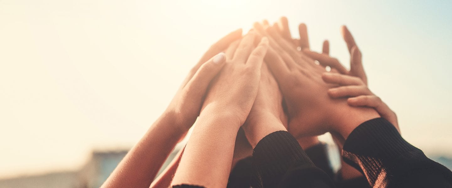 Group of Teenagers Volunteer with Raised Hands to the Sky