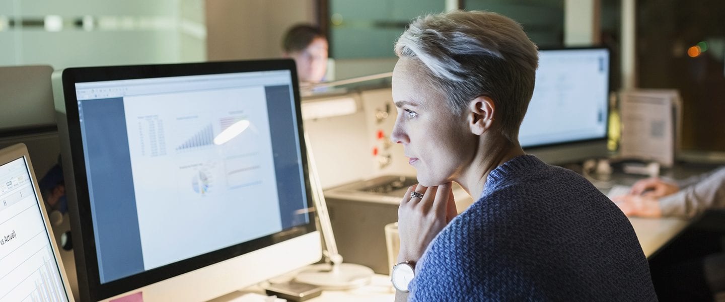 A health industry professional examines information on a computer screen